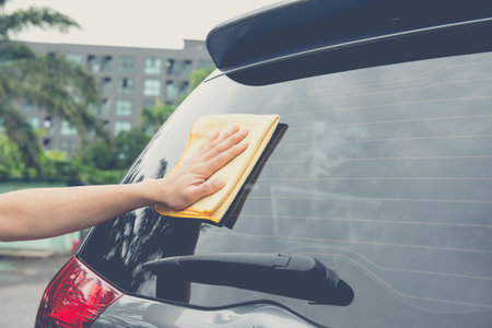 Worker cleaning  car with microfiber cloth, car detailing selective focus concept.の写真素材