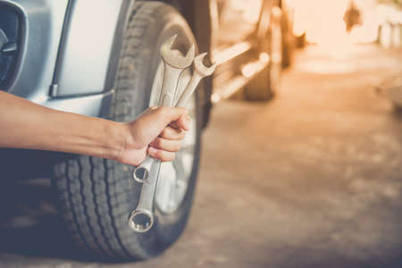 A man checking the auto engine,  uses a wrench to fix the car engine,repair service.の写真素材
