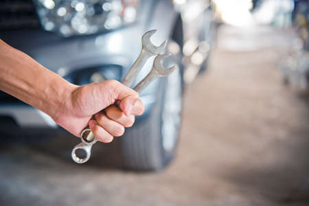 A man checking the auto engine,  uses a wrench to fix the car engine,repair service.の写真素材