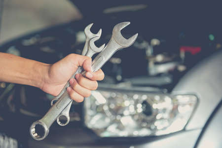 A man checking the auto engine,  uses a wrench to fix the car engine,repair serviceの写真素材