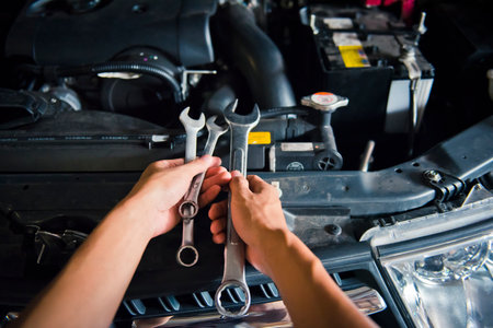 A man checking the auto engine,  uses a wrench to fix the car engine,repair serviceの写真素材