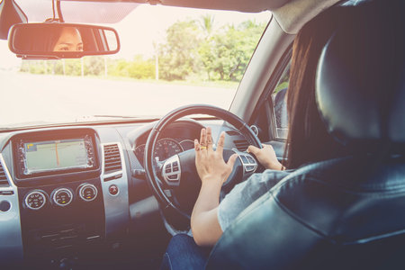 Man is holding the steering wheel of car to control while driving and use hand press Horn of carの写真素材