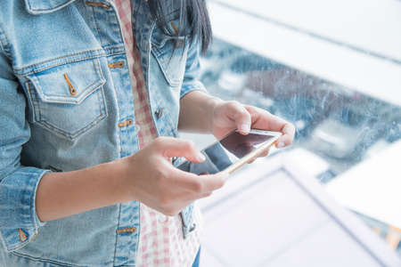 Young woman using cellphone in shopping mallの写真素材
