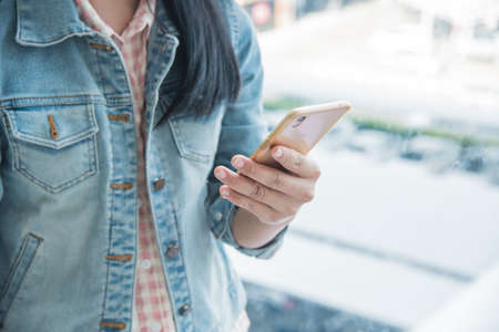 Young woman using cellphone in shopping mallの写真素材