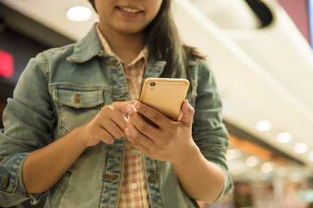 Young woman using cellphone in shopping mall