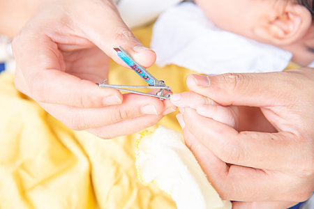 Mother cutting babies nailsの写真素材