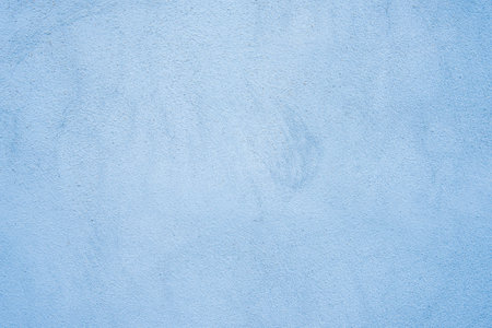 Rough cement studio background, Light cyan painted stucco wall texture for product presentation backdrop.の写真素材