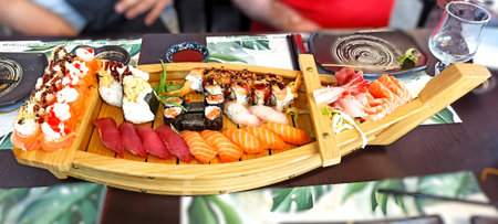 Sushi set in a wooden plate on a table in a restaurantの写真素材