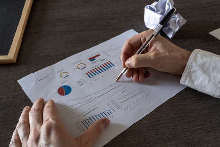 Finance employee analyzing the latest company charts and looking for the best way to present them to shareholders.の写真素材