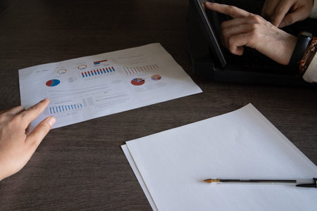 Close-up of co-workers working on the presentation of financial information of the company with the...