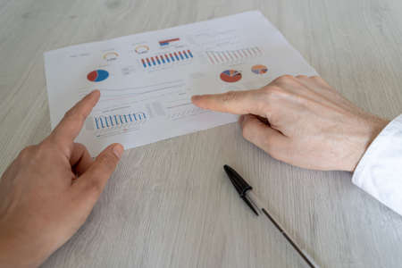 Accounting employee presenting the latest results of the company to his superior with graphs and ratesの写真素材