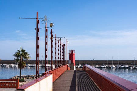 Walkway to the red lighthouse of the port of Javea on the Costa Blanca, Alicante, Spain.の写真素材