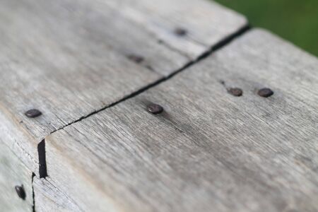 detail of a rusty nail in a wood, which is the railing, in a pairの写真素材
