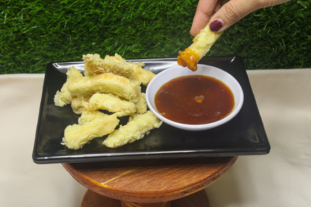 Fried Bread with Sweet and Sour Sauce on a Black Plateの写真素材