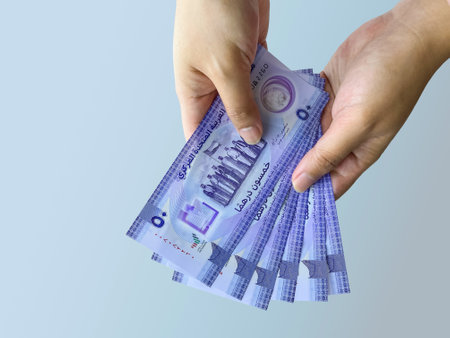 Closeup of female hands holding new UAE 50 dirhams currency notes, paper money, against white background, released on Dec, 2021 to mark Golden jubilee. Finance and Economy concepts.の写真素材
