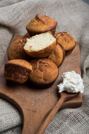 muffines on wooden board and domestic chees on spoon