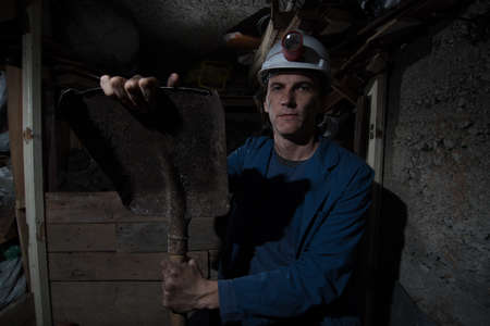 miner sitting and holding shovelの写真素材