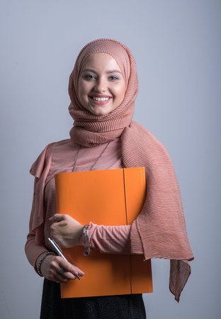 young woman smiling and holding filesの写真素材