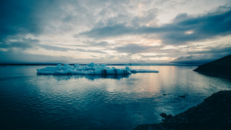 A mighty iceberg floats in the Joekulsarlon glacier lagoon in the romantic evening light.の写真素材