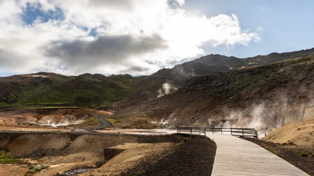 Hiking trail through the active Krysuvik geothermal area surrounded by columns of steam and clouds of smoke.の写真素材