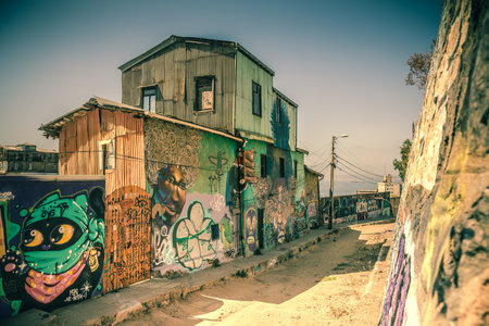 Old corrugated iron houses colorfully painted with crazy street art in the streets of Valparaiso, Chile.の写真素材