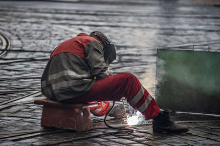 worker repairing the tram tracks, is welding with an electric welderの写真素材