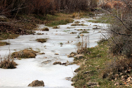 Fuente del Berro river frozen as it passes through Calomarde in the AlbarracÃ­n mountain range.の写真素材