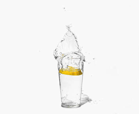 glass of clear water with a splash of lemonの写真素材