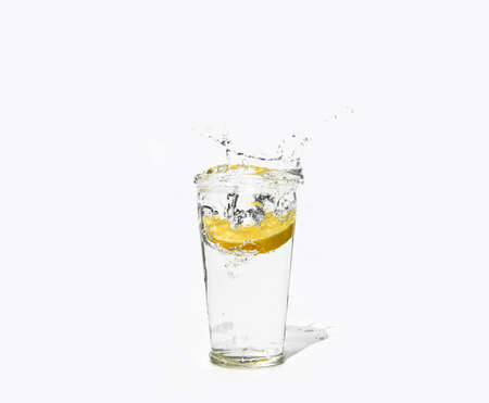 glass of clear water with a splash of lemonの写真素材