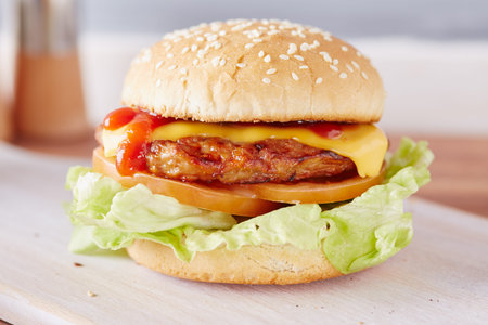 cheeseburger on a white chopping boardの写真素材