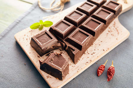Dark chocolate on a white chopping board, light and bright colorsの写真素材