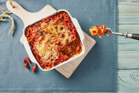 Baked anelletti pasta with mince, sauce and mozzarella. Typical sicilian dishの写真素材