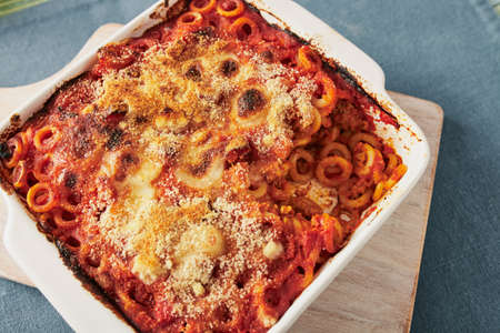 Baked anelletti pasta with mince, sauce and mozzarella. Typical sicilian dishの写真素材