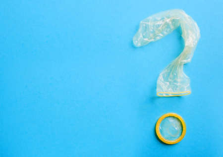 Condom in the shape of question mark on blue backgroundの写真素材