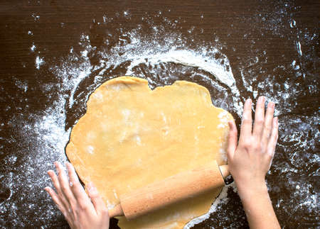 Woman's hands roll the dough. Protection Symbol, heat comfort.の写真素材