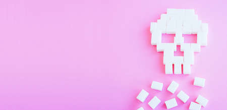 The skull made of sugar cubes. Sugar kills. Pink backgroundの写真素材