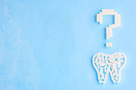 Question mark made of sugar cubes on blue background, symbolの写真素材