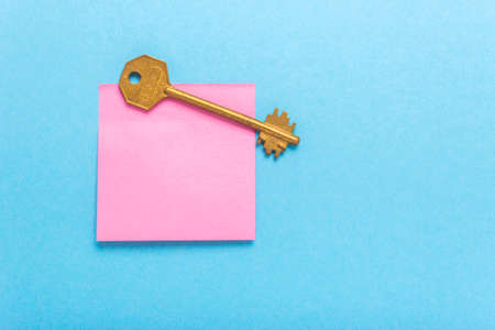 Adhesive note post and key on a blue backgroundの写真素材