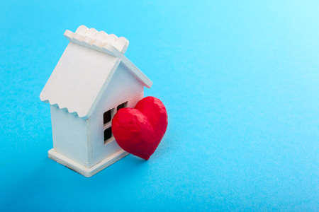 Red heart and white house. Sweet house. Blue backgroundの写真素材