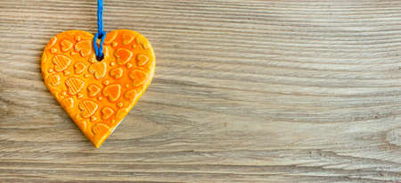 Orange heart from ceramic on wooden background with space empty space for textの写真素材