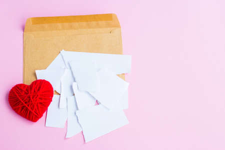 Love letter torn with red hearts on a pink background, empty letterの写真素材