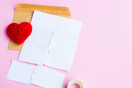 Love letter torn with red hearts on a pink background, empty letter