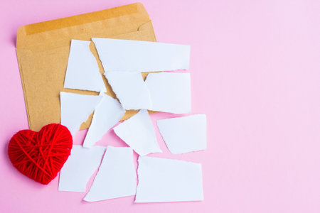 Love letter torn with red hearts on a pink background, empty letter