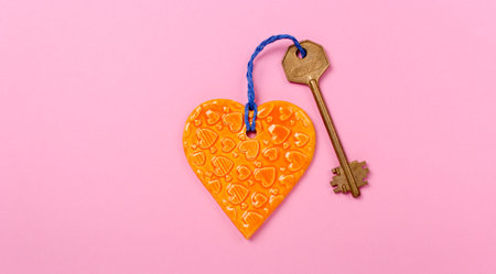 Golden key and Orange heart on a pink backgroundの写真素材