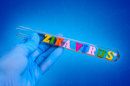 Words virus zika of colored wooden letters in test-tube. Hand in glove holding a test tube on a blue backgroundの写真素材