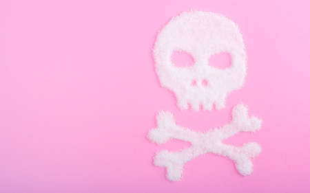 The skull made of sugar. Sugar kills. Pink backgroundの写真素材