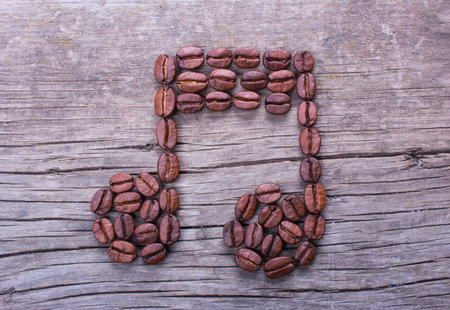 Music note from coffee beans on old wooden table