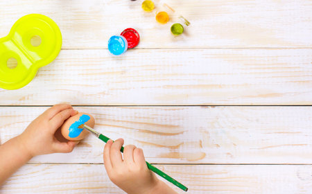 A mother and  kid painting Easter eggs