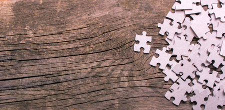 Puzzle pieces with empty space for text on an old wooden tableの写真素材