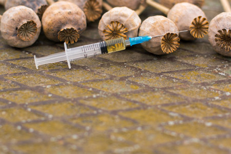 Drug opium poppy inside the syringe. Deadly drug addiction. On an old rusty background. Empty space for textの写真素材